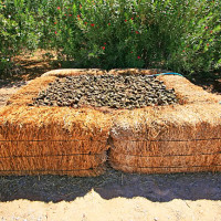 A compost bin made with bales of hay
